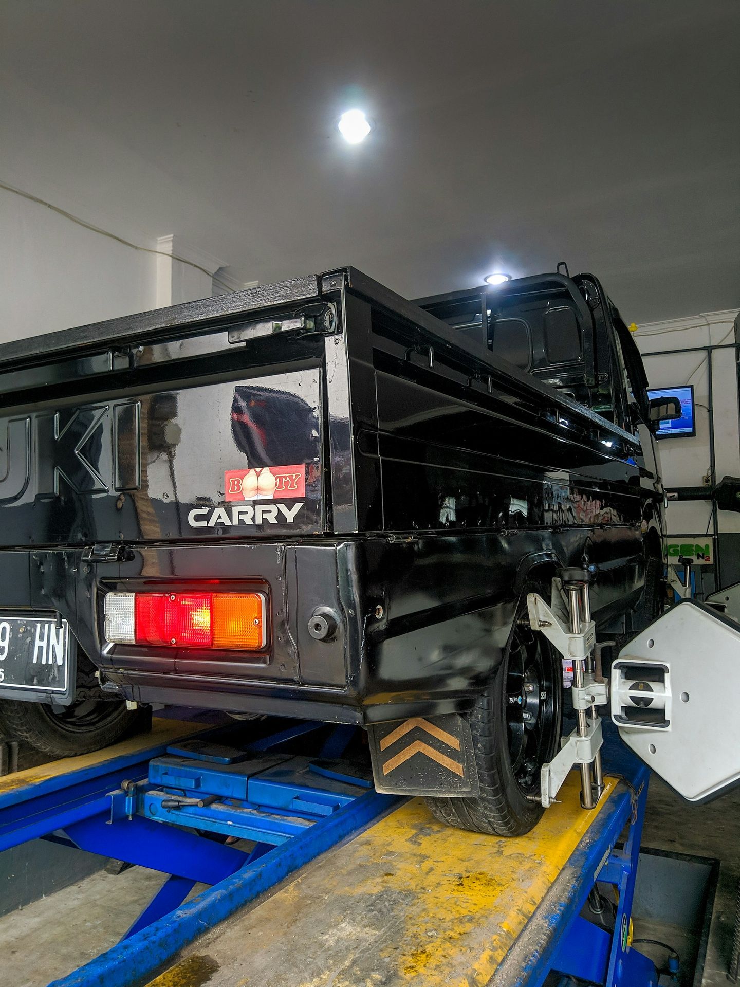 a black truck is being worked on in a garage